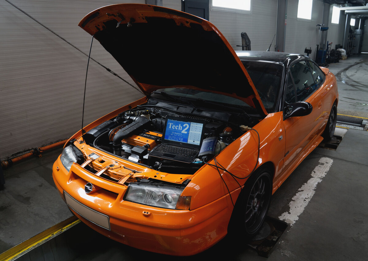 Opel Calibra portocaliu cu echipament Tech2 conectat la motor - diagnosticare Service Adam Cluj
